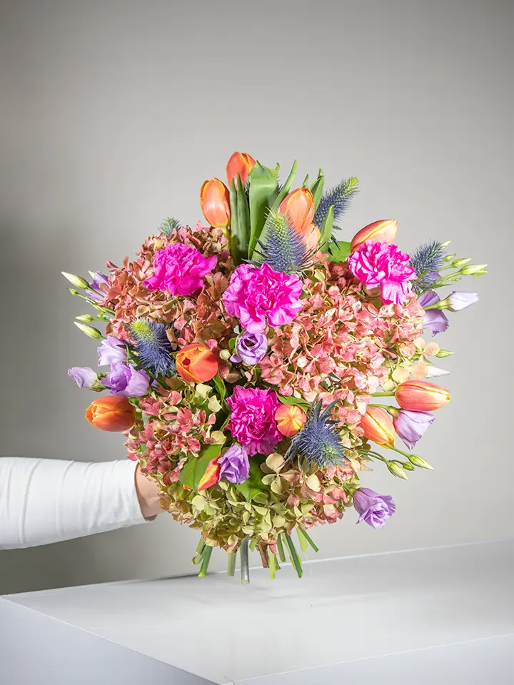 Bouquet con ortensia garofani tulipani eryngium in mano